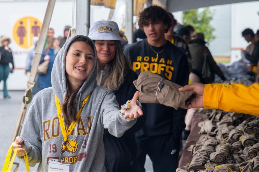 a newly accepted student reaching out her hand to receive a free t-shirt