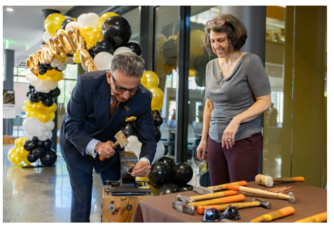 Image of President Ali Houshmand participating in copper forging demonstration with Donna Sweigart, Art Department Chair