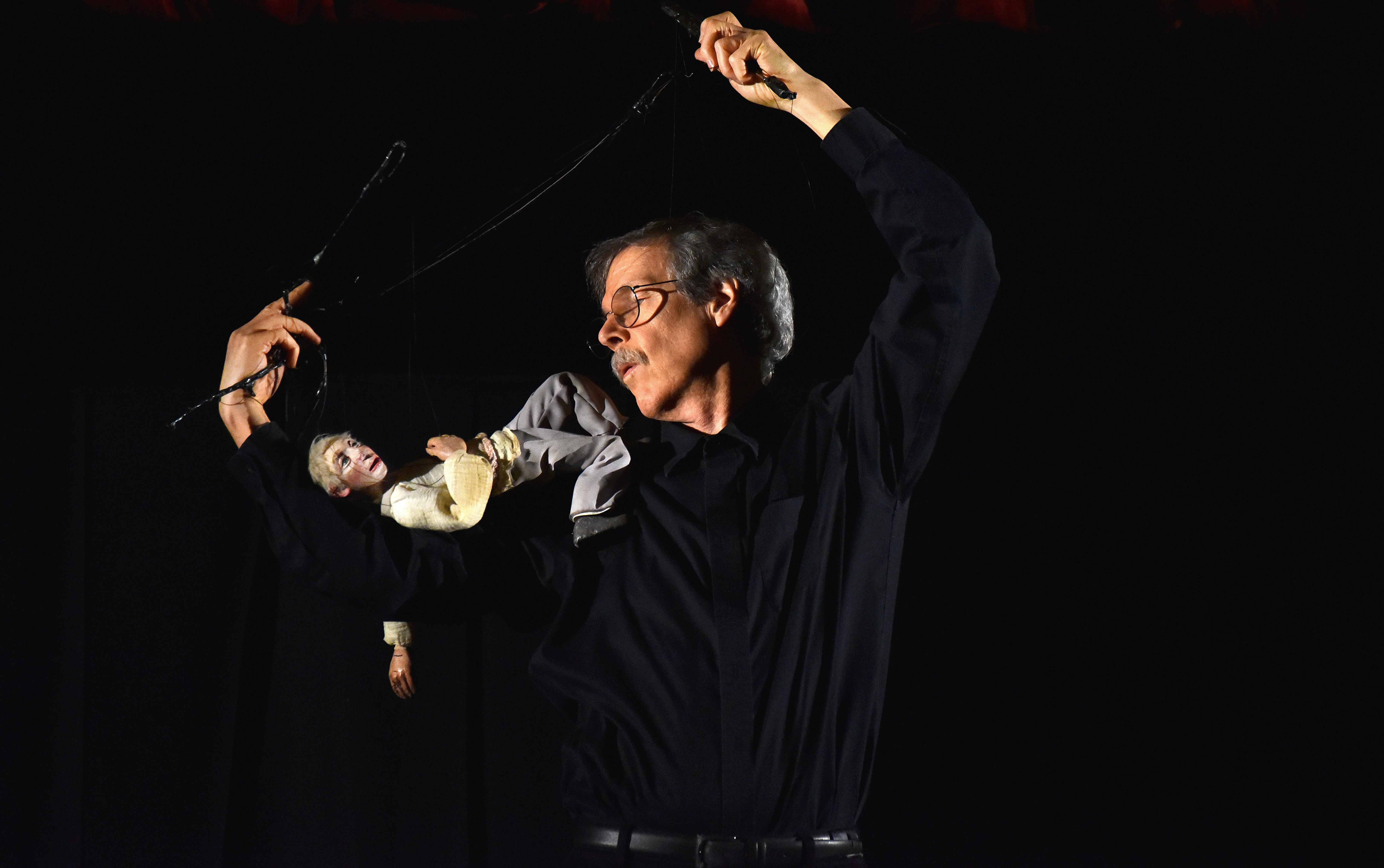 John Cashore with a marionette resting on his shoulder as if sitting under a tree
