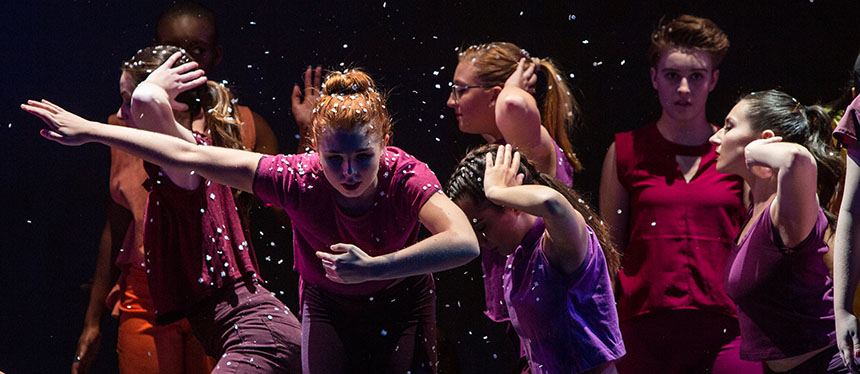 dancers looking toward the ground with arms pointing to the left