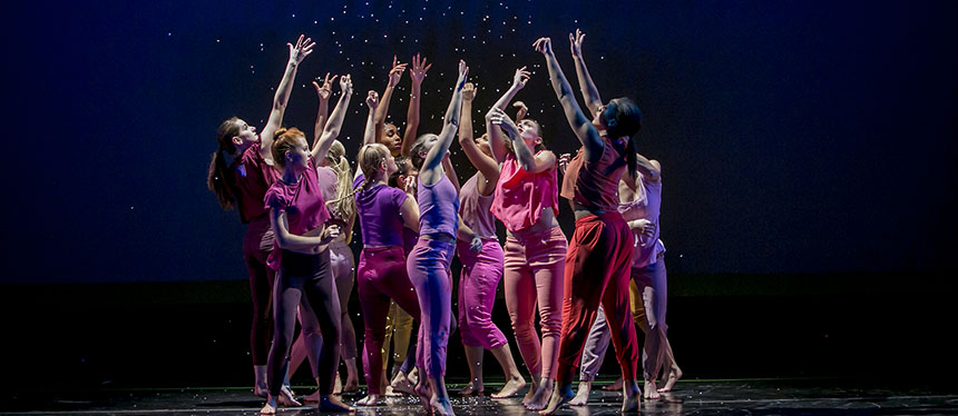 dancers gathered together looking upward