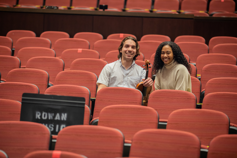 a man and a woman sitting in the audience of pfleeger concert hall