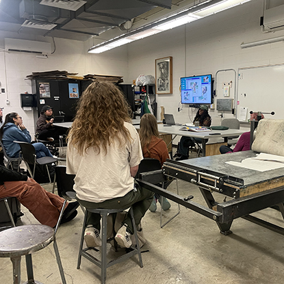 Qualeasha Wood speaks to a group of students in an art classroom.