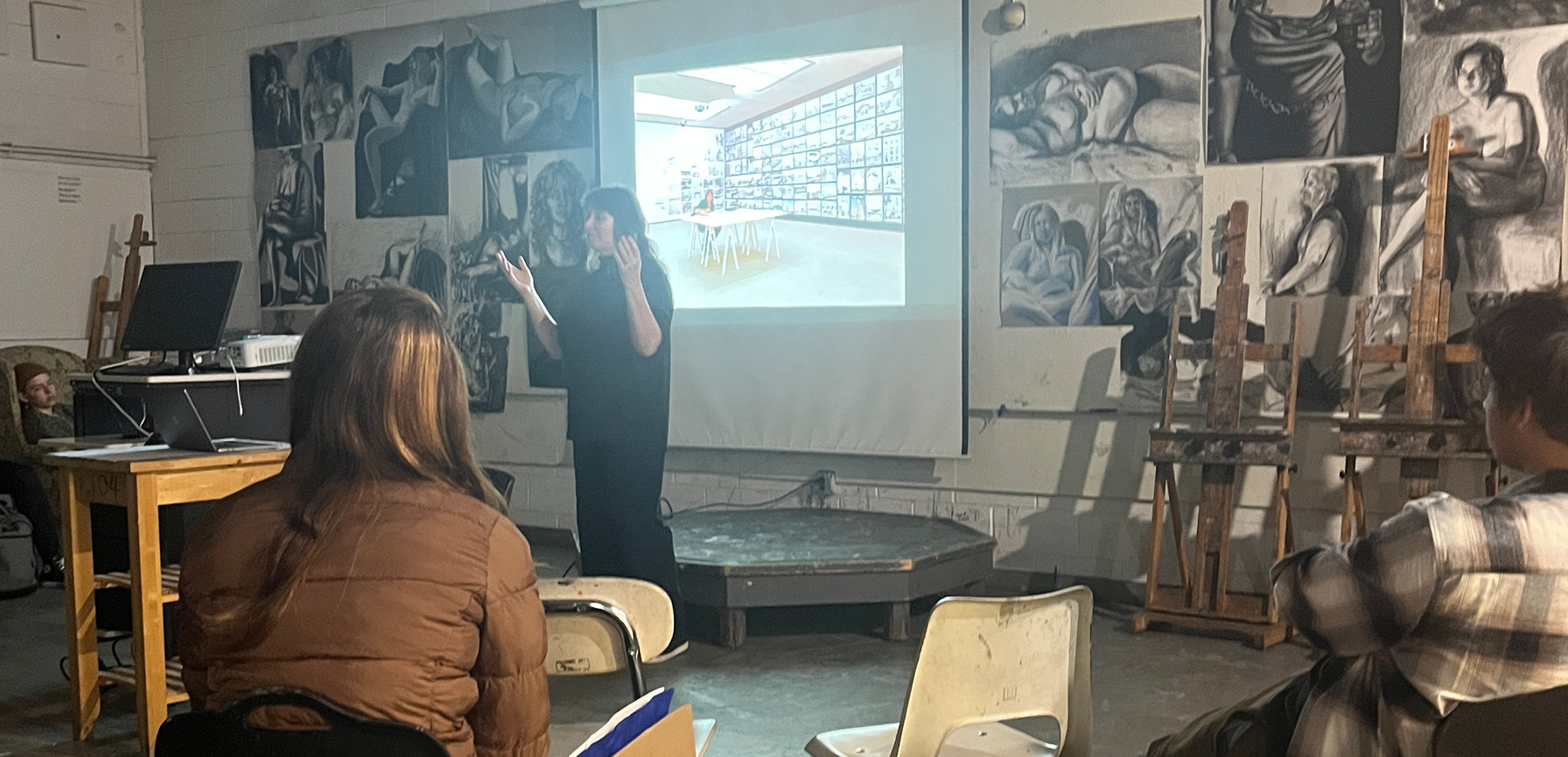 Ellen Harvey speaking to a group of students in an art classroom.