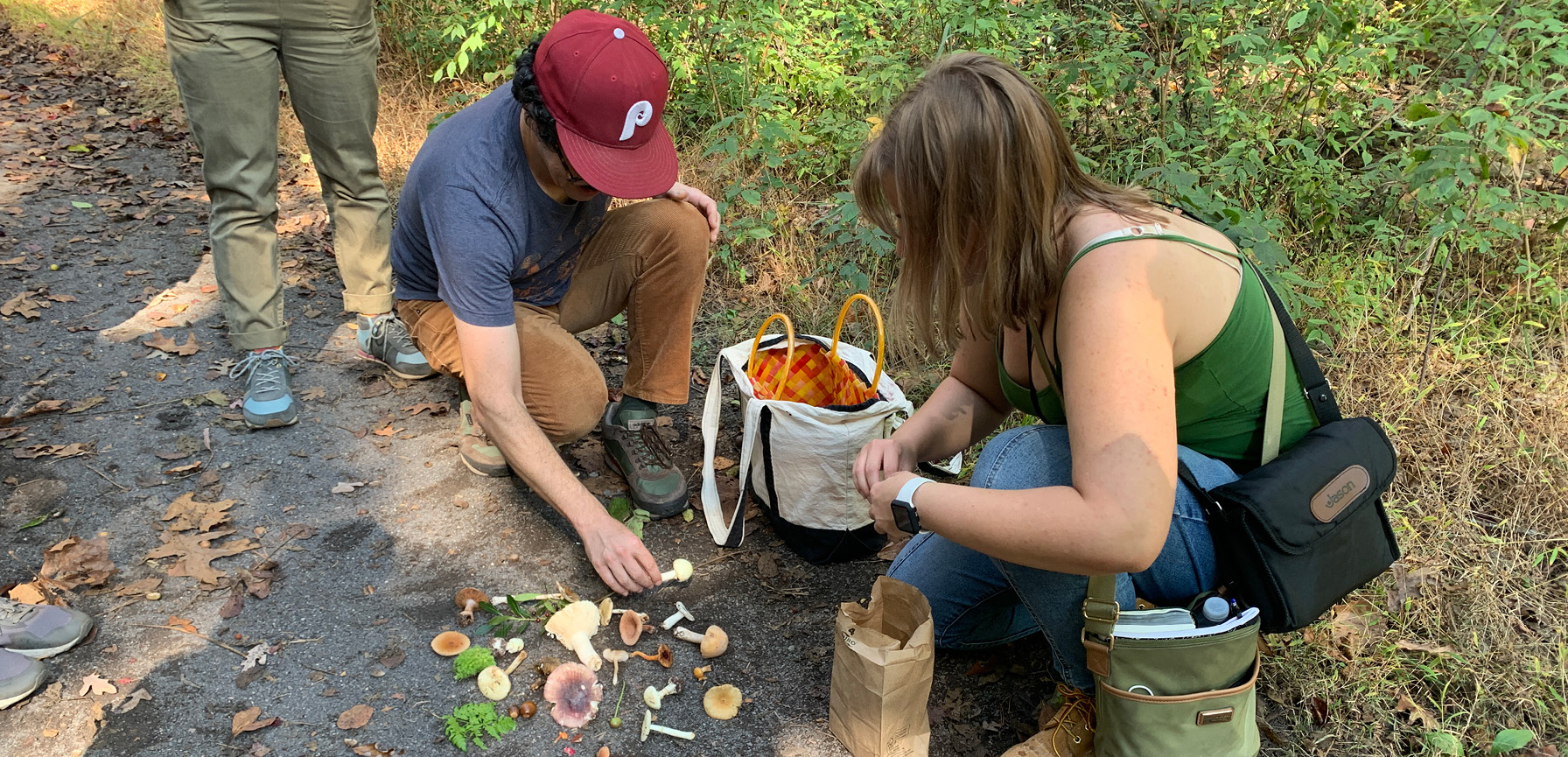 Matthew Suib and a student display the items they foraged on a nature walk.
