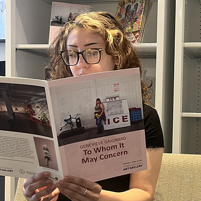 Student reading exhibition catalog.