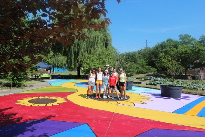 This is an image of CMSRU students (and members of ARTx Camden) posing with the newly painted ground mural.