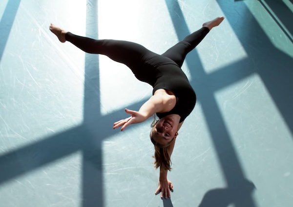 A drone photo of a student doing a handstand in a dance studio.