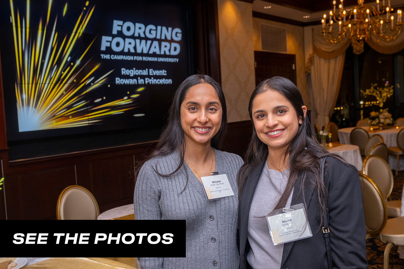 Two alumni pose for a group photo with a button that says "See the photos."