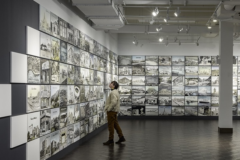 One student looking at a wall of images on display.