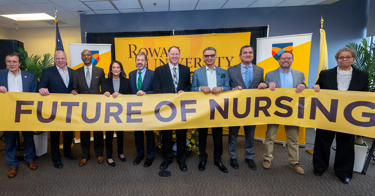 A group of Rowan official hold a "Rowan Nursing" banner.