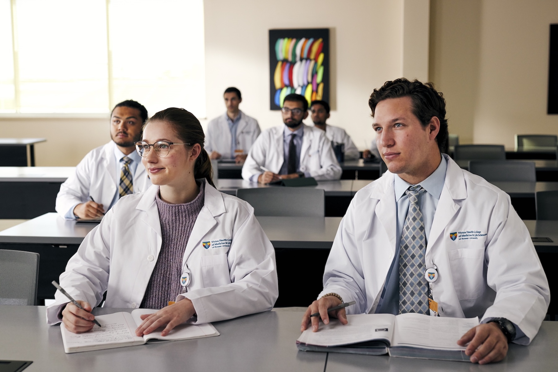 Two future doctors sit in a classroom.