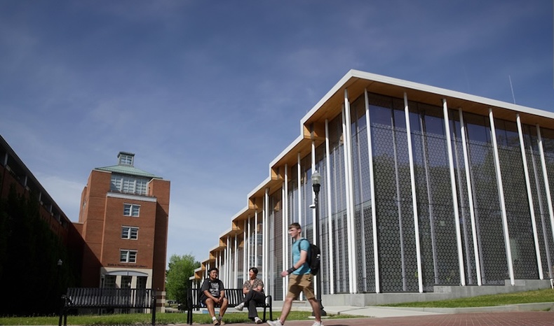 A wide shot of the Student Center with a student on a skateboard riding by.
