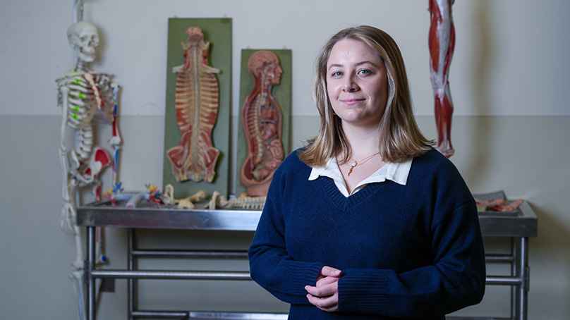 A portrait of a student with an anatomical diagram of a muscle system.
