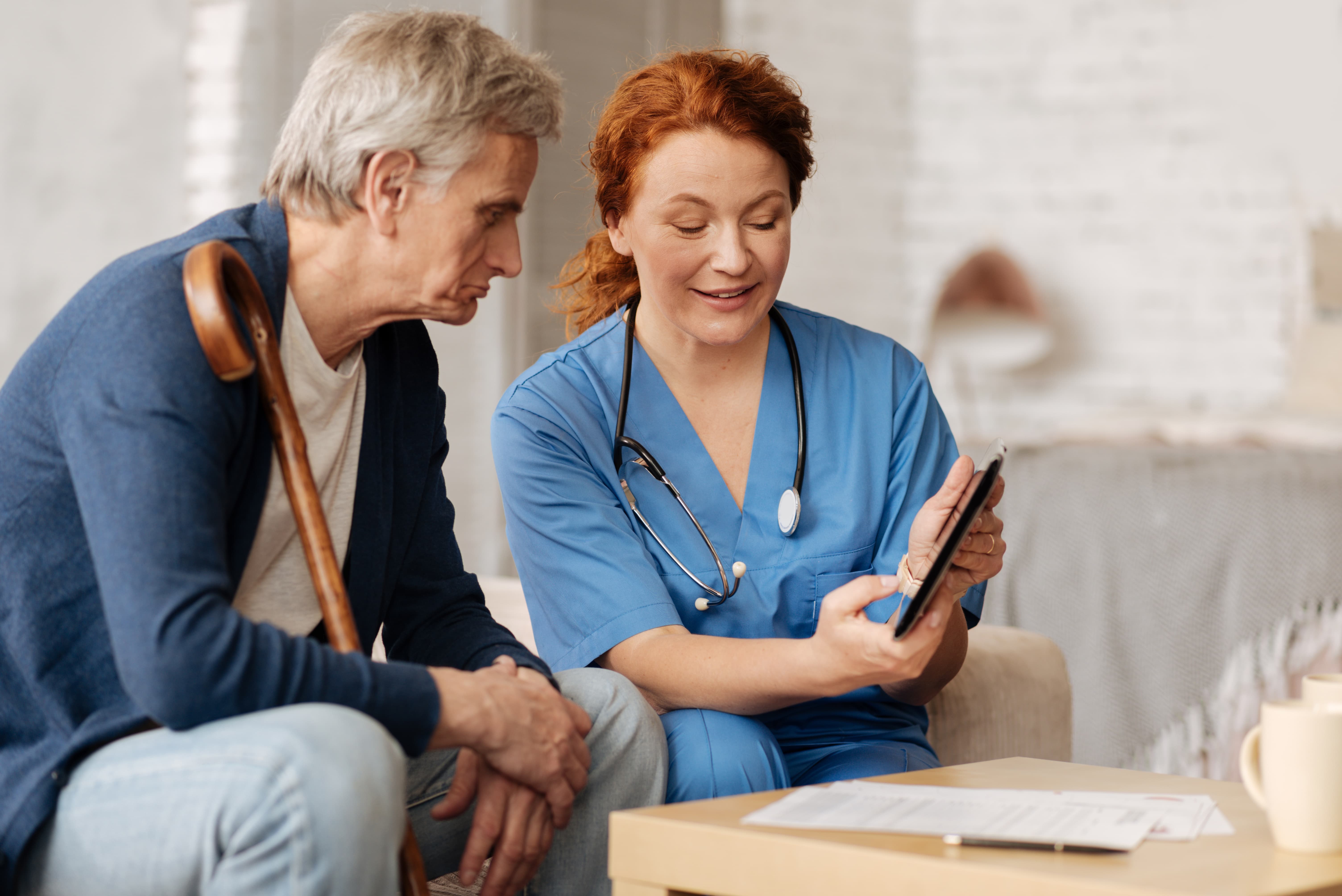 nurse practitioner talks with a patient at bedside.