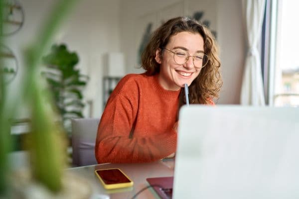 A student smiles while writing in their folder.