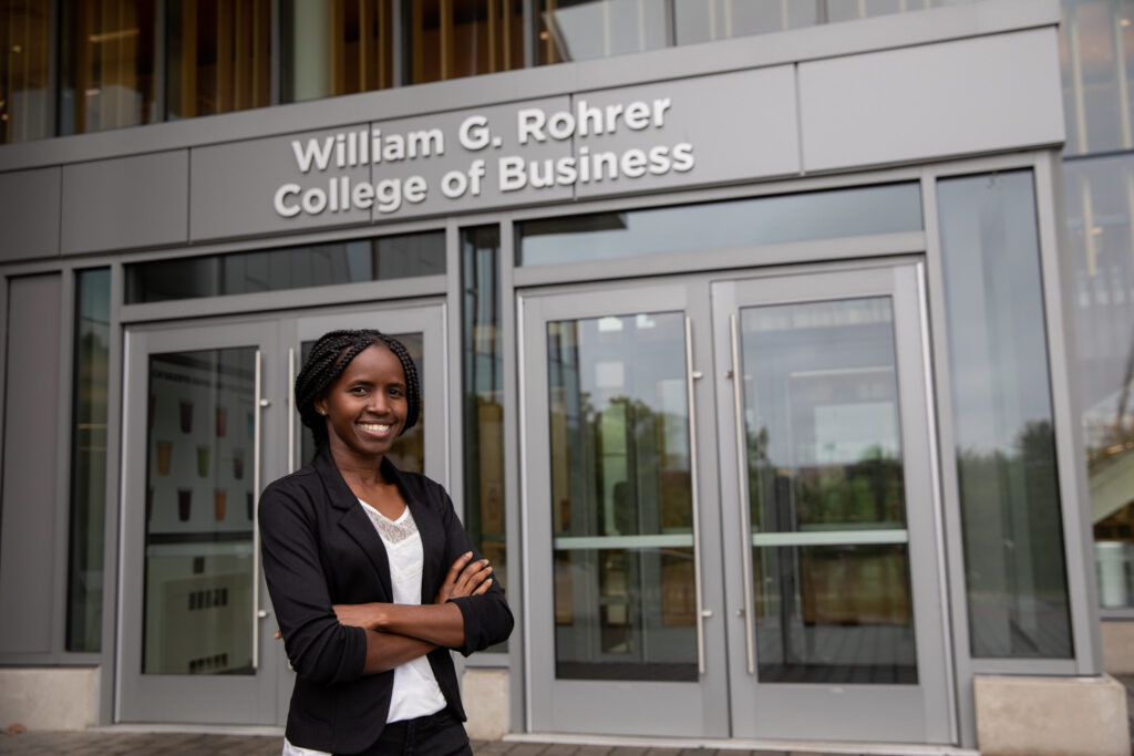 A student stands in front of the Rohrer College of Business building on Rowan's main campus in Glassboro, NJ.