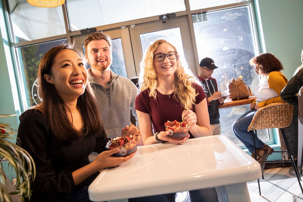 A group of four Rowan students walk on a sidewalk on Rowan University's main campus in Glassboro, NJ.