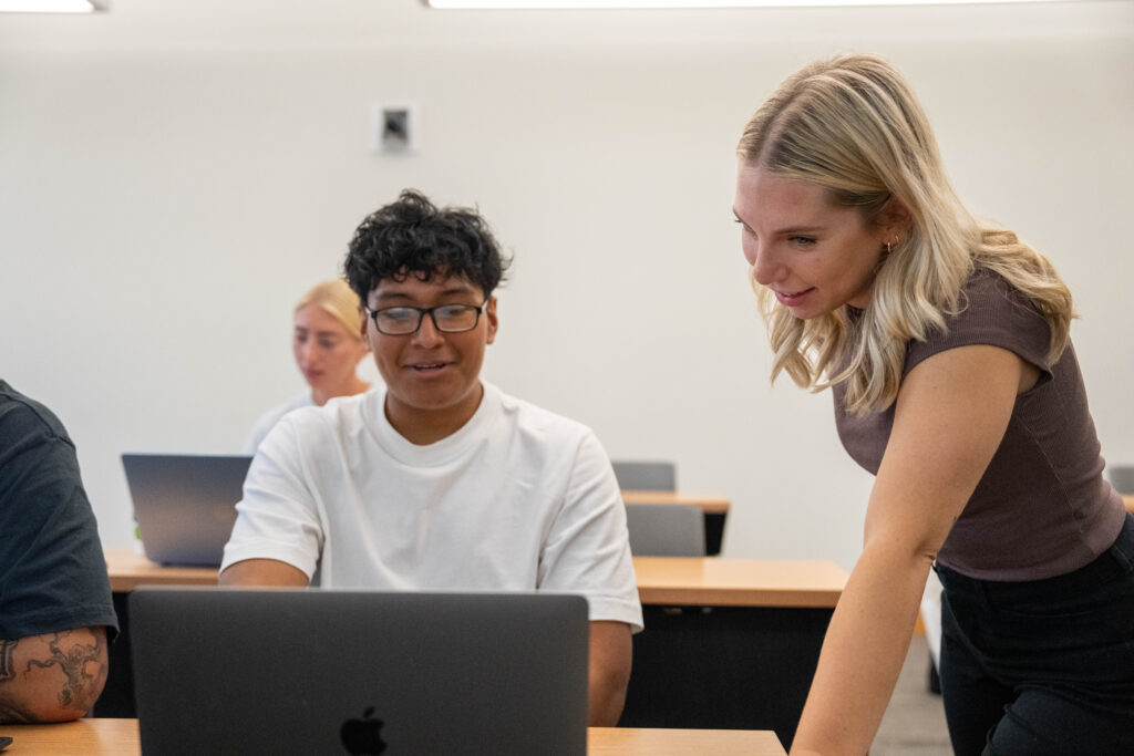 Samantha L. helps a student.