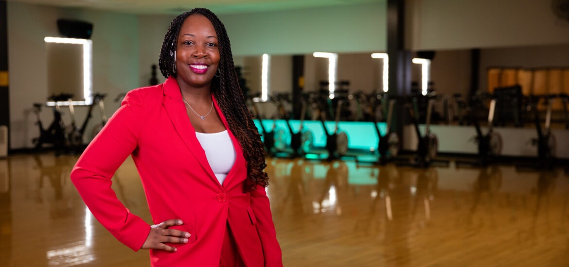 A student stands in front of fitness machines.