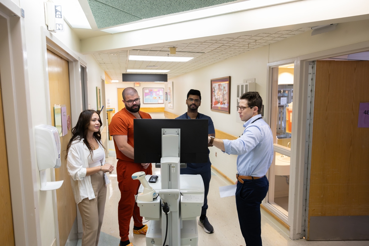 A group of medical students gather for a discussion in the hallway.
