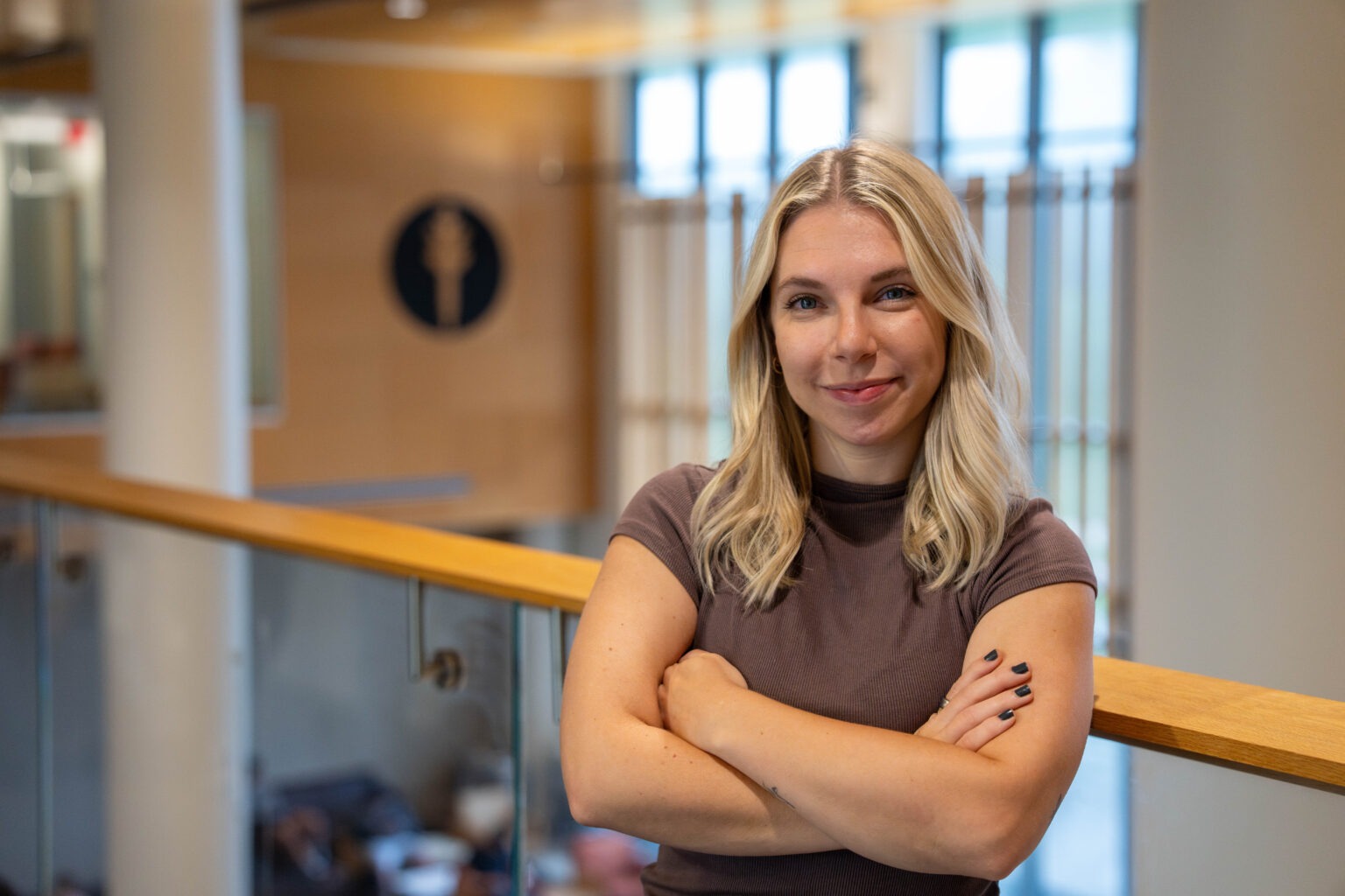 Samantha L. smiles while standing in a building on Rowan's main campus in Glassboro, NJ.