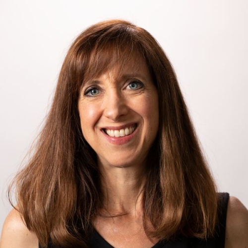 Jessica Hunter with long red hair wearing a black sleeveless shirt smiling at the camera.