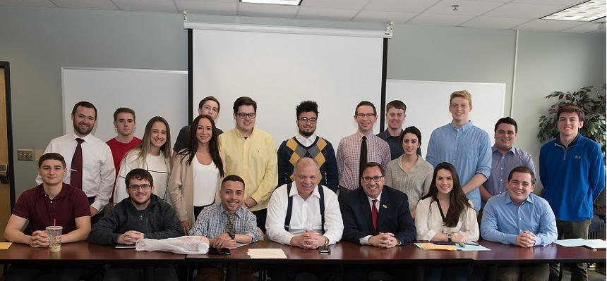 Steve Sweeney surrounded by students in a classroom