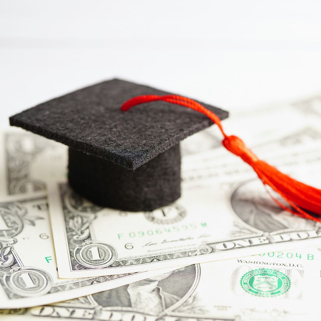 Image of academic cap resting on dollars