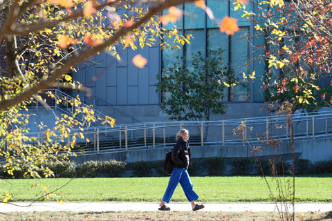 student walking on campus sidewalk