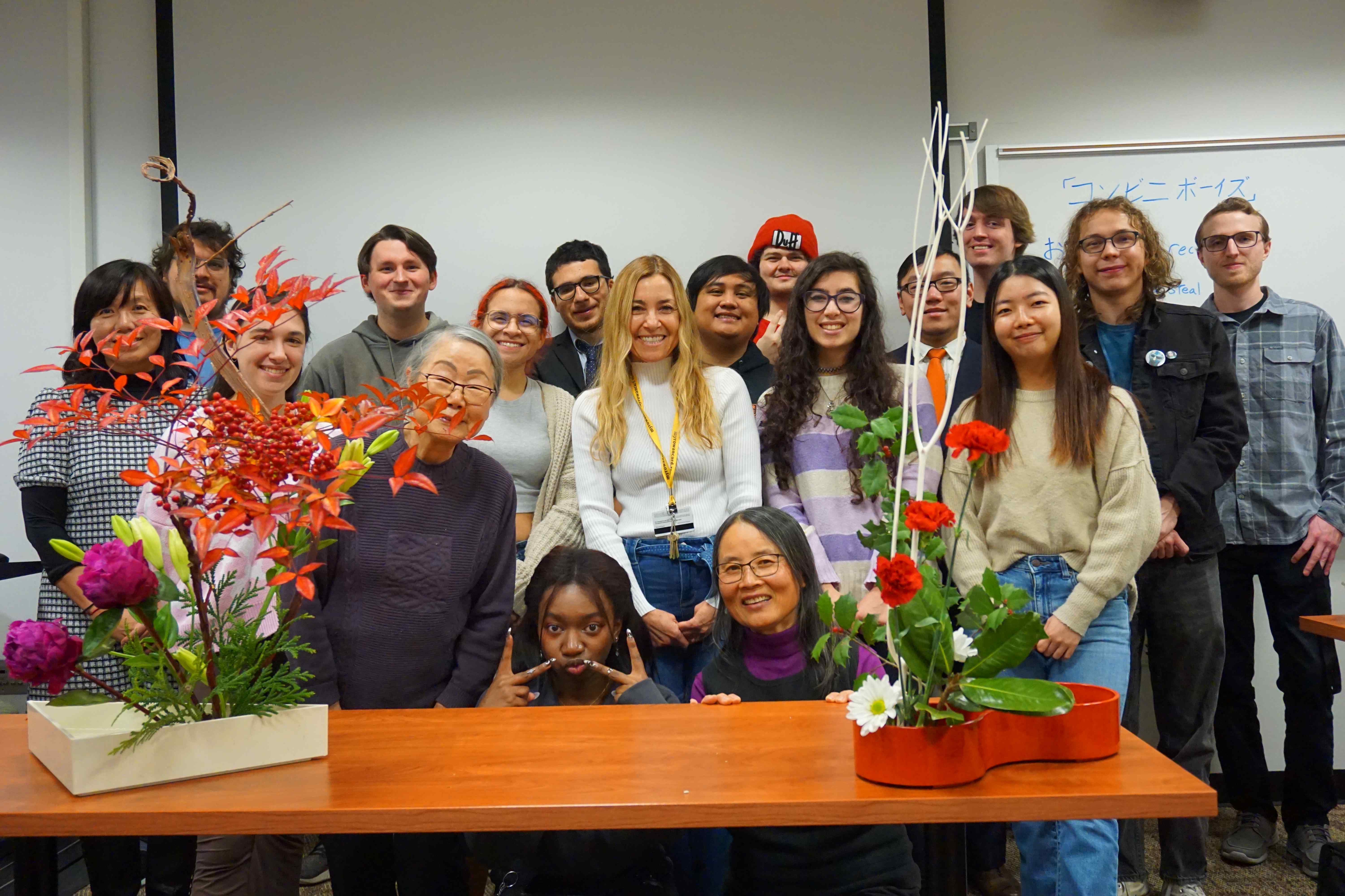 Group of students with Professor Dusk and Mrs. Mariko Ono smiling behind an Ikebana demonstration.