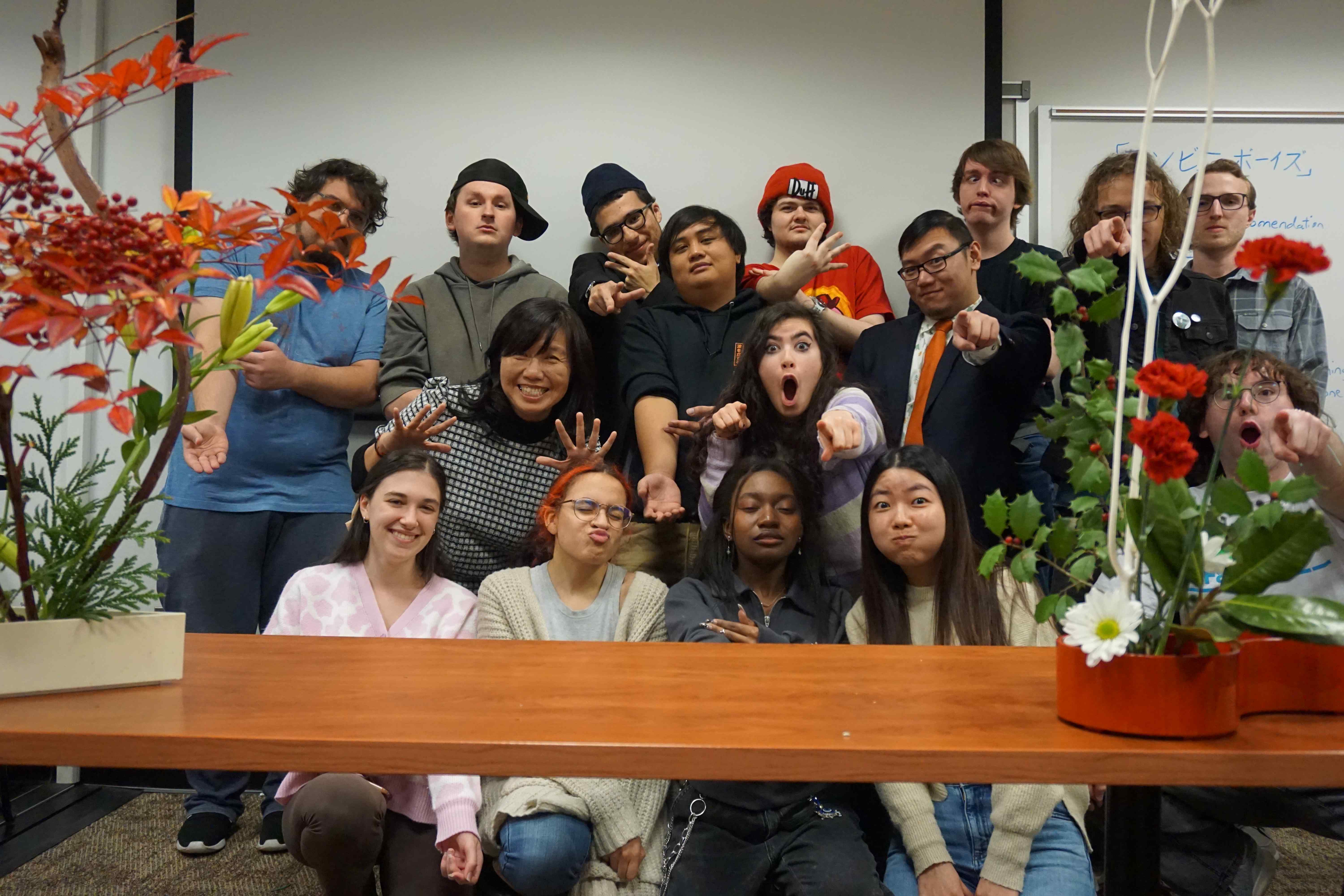 Group of students and Professor Dusk smiling behind an Ikebana demonstration.