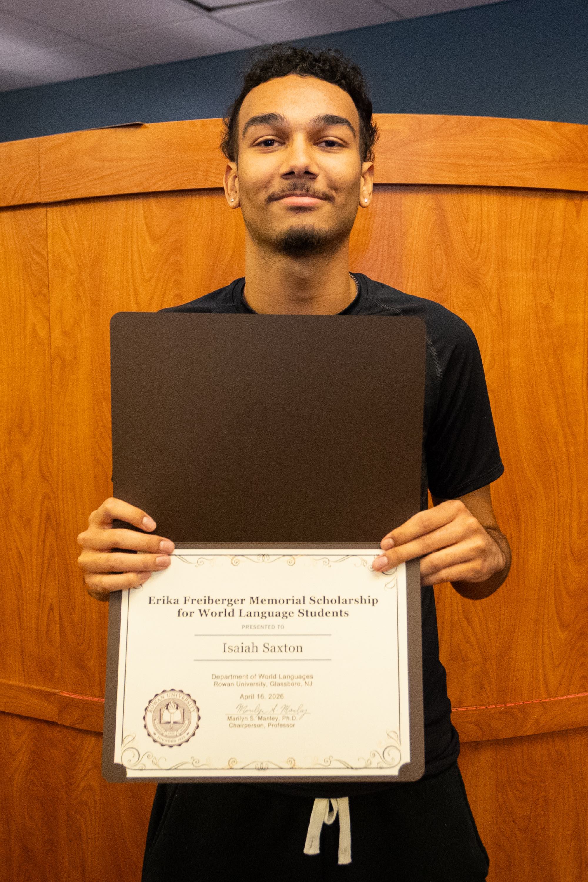 Student awardee smiling with certificate.
