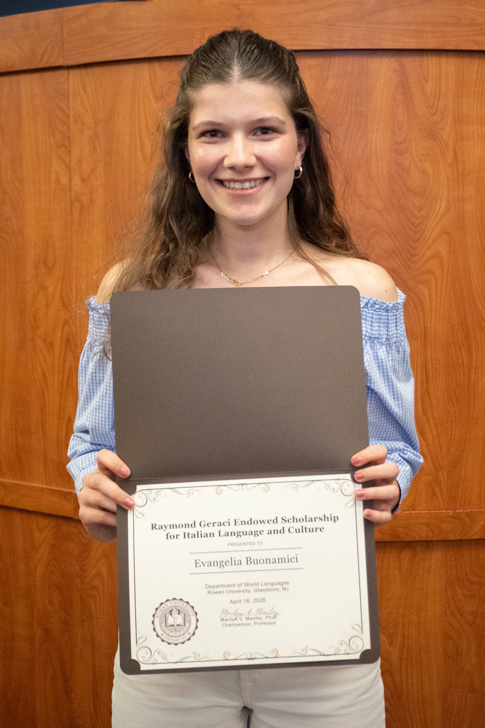 Student awardee smiling with certificate.