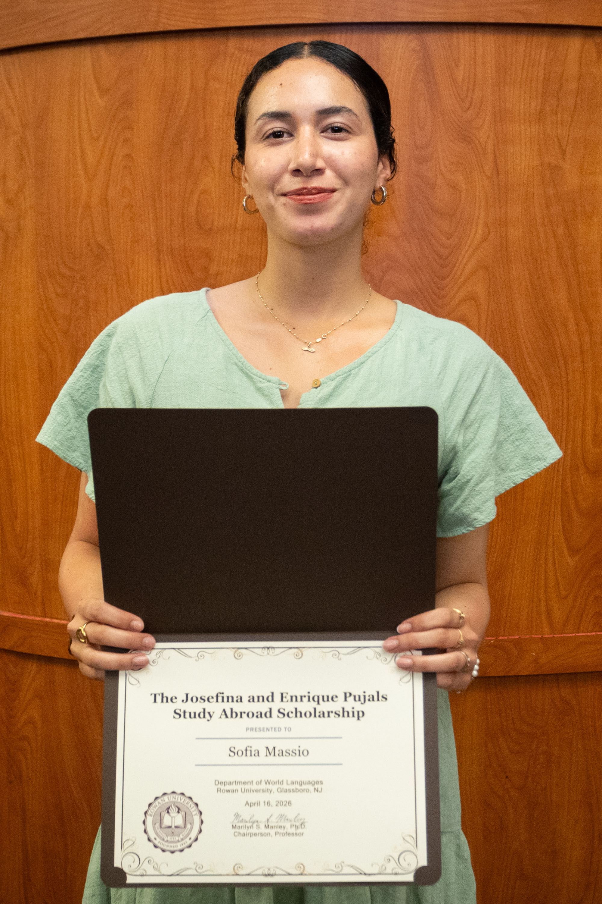 Student awardee smiling with certificate.