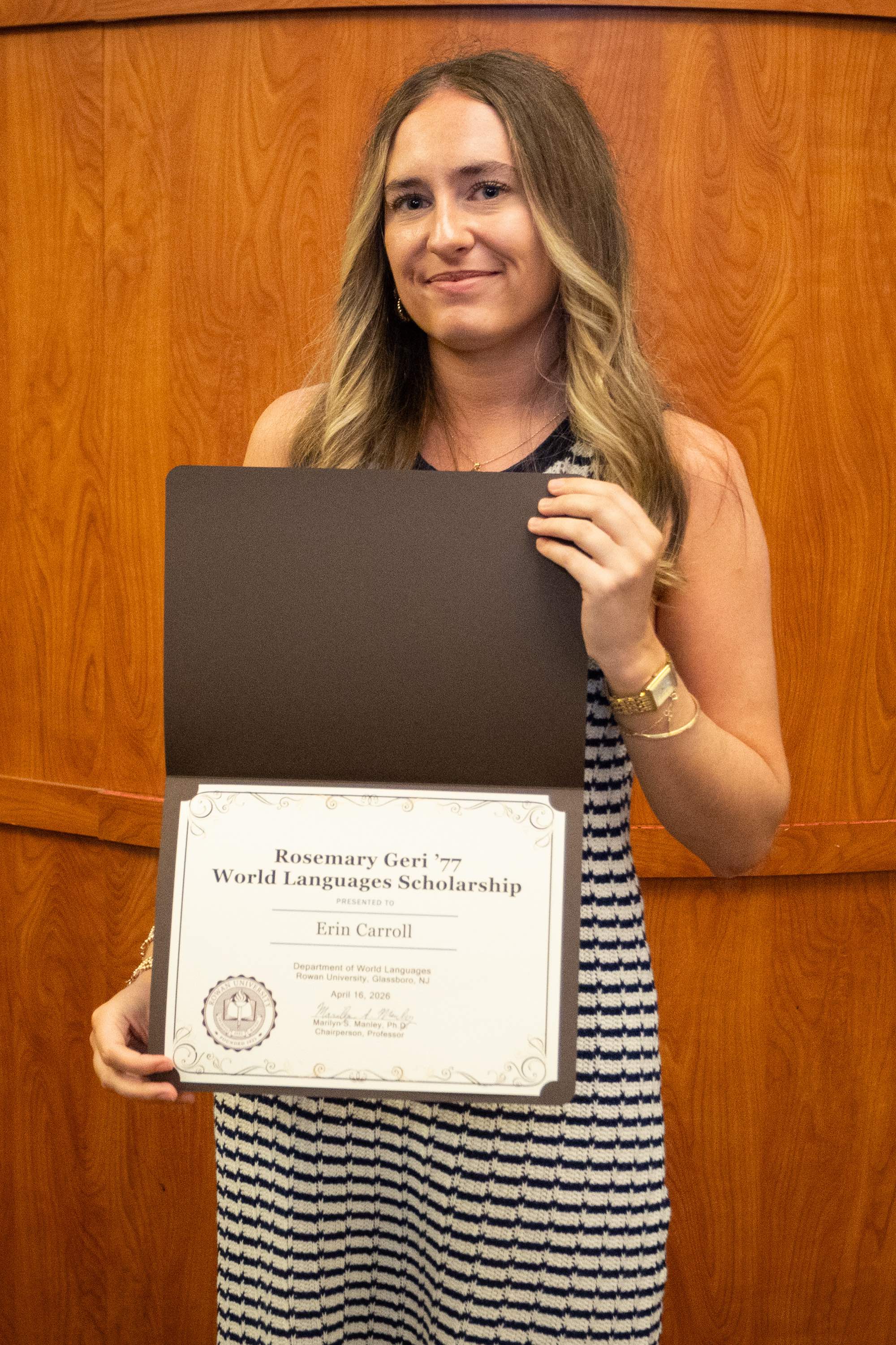 Student awardee smiling with certificate.