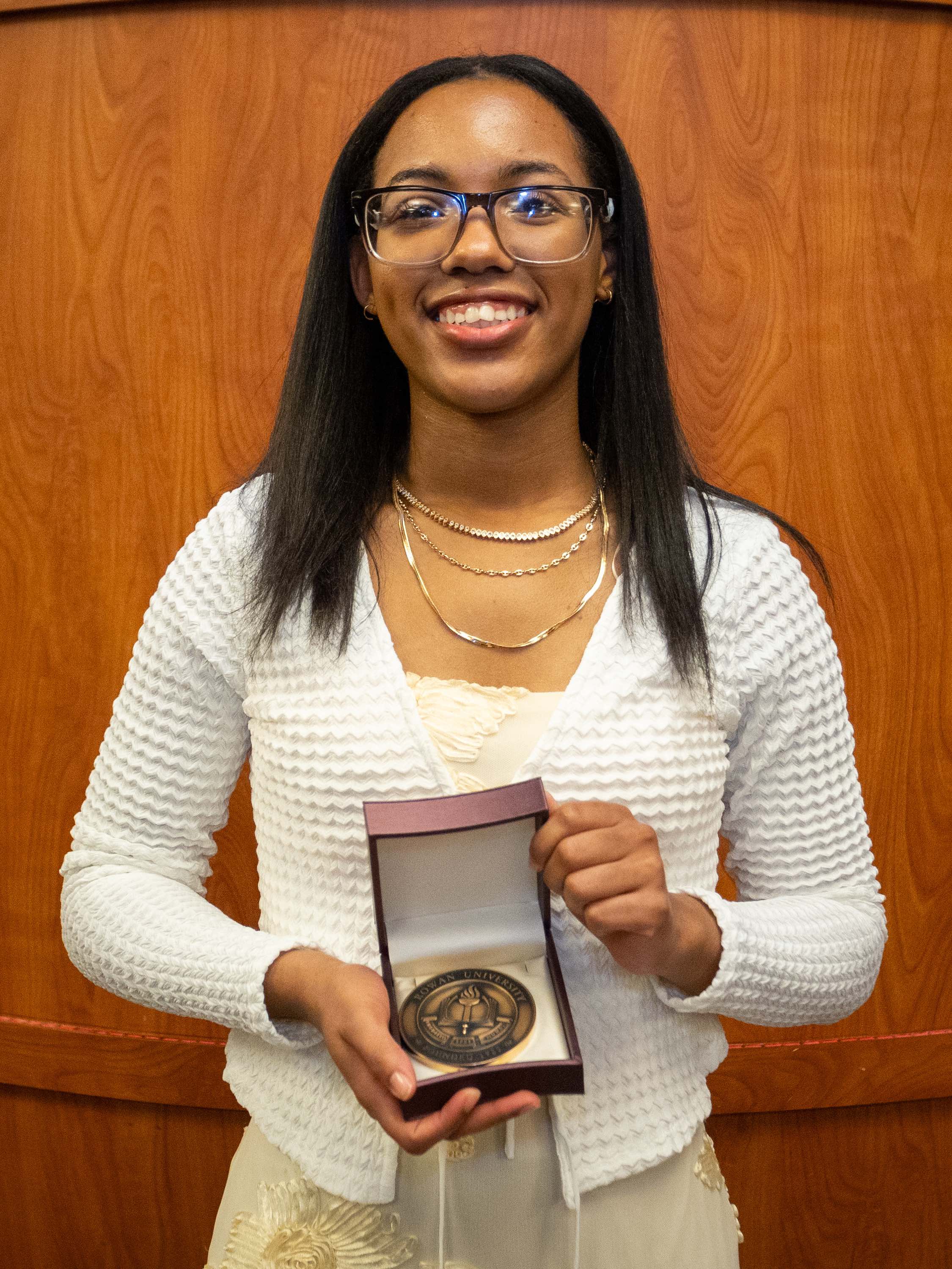 Student awardee smiling with certificate.