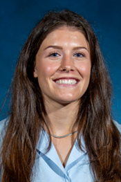 Corinne Gallagher smiles while wearing a light blue shirt