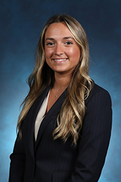 Eleni Papadopolous smiles while wearing a black blazer and a white shirt