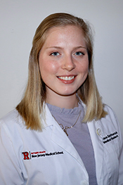 Grace Smithwick smiles while wearing her Rutgers white coat