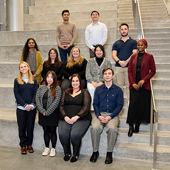 a photo of the 12 doctoral fellows on the steps inside the Research Tower